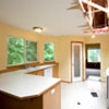House Repair Edmonds, WA: BEFORE Picture of the kitchen pre-restoration. Kitchen Ceiling is destroyed by a fallen tree, all kitchen appliances are missing. Kitchen Cabinets are stained and water-damaged. Kitchen Counter Tops are de-laminating
