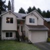House Remodel Everett, WA: BEFORE - Deteriorating LP lap and panel siding, Deteriorating fascia, Insufficient gutter downspouts, Insufficient exterior lighting, Failing Cedar Front Porch