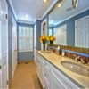 Bathroom Remodel Seattle. AFTER: Bathroom Flooring - Heated Tile Floor Porcelain 13x26 tile, Bathroom Counter - Quartz Counter Top with Custom Glass Title Back Splash, New Under Mounted Sinks, Custom Mirror, Floor Lighting, Wall Finish-Smooth Wall